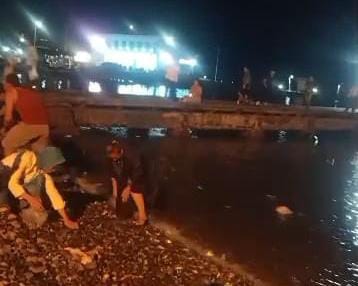 Potret seorang warga yang sedang berebut ikan yang loncat ke daratan